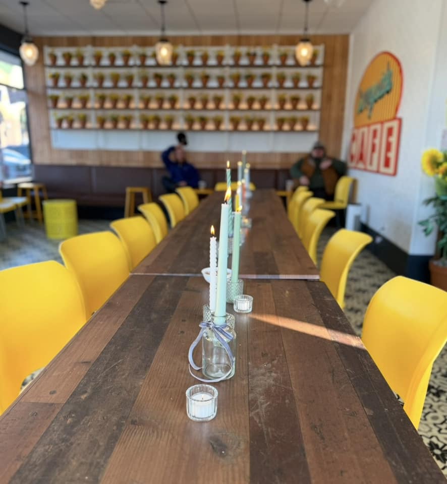 Dining room rental in Williamston at Sunnyside Cafe, with a long table and yellow chairs